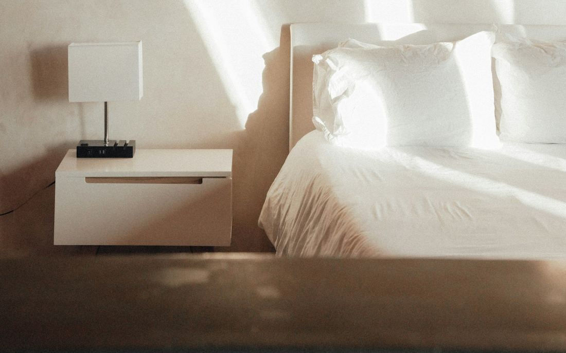Sunlit bedroom with a bedside table